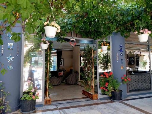 Asma ve çiçekli saksılarla çevrili otel girişi